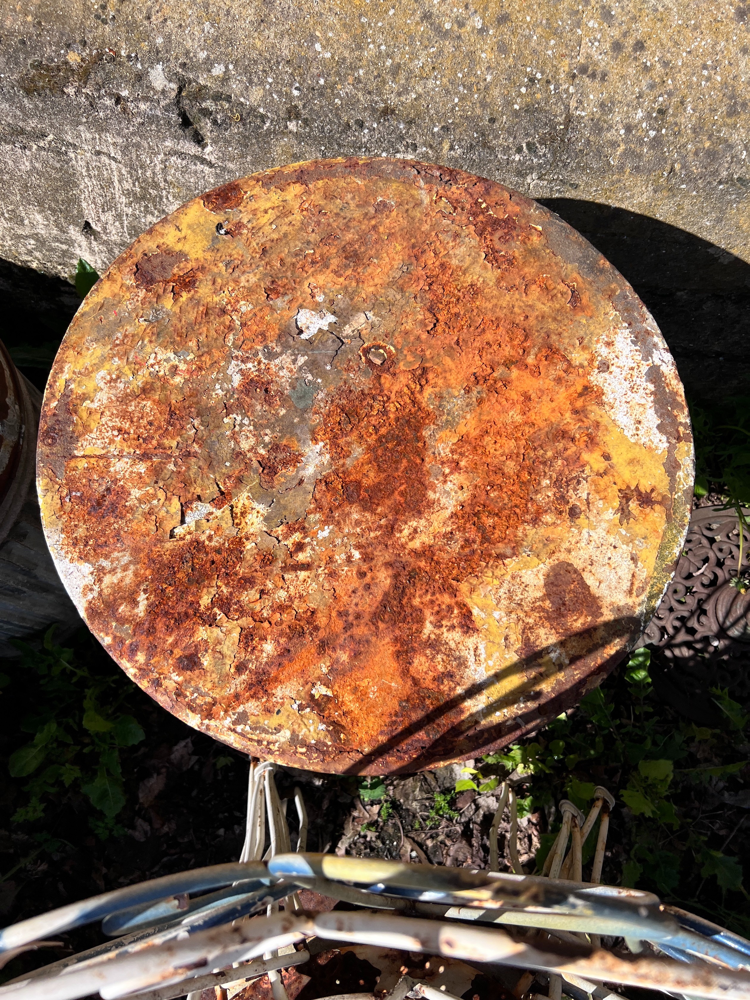 A circular wrought iron garden table and four chairs, diameter 50cm, height 80cm *Please note the sale commences at 9am.